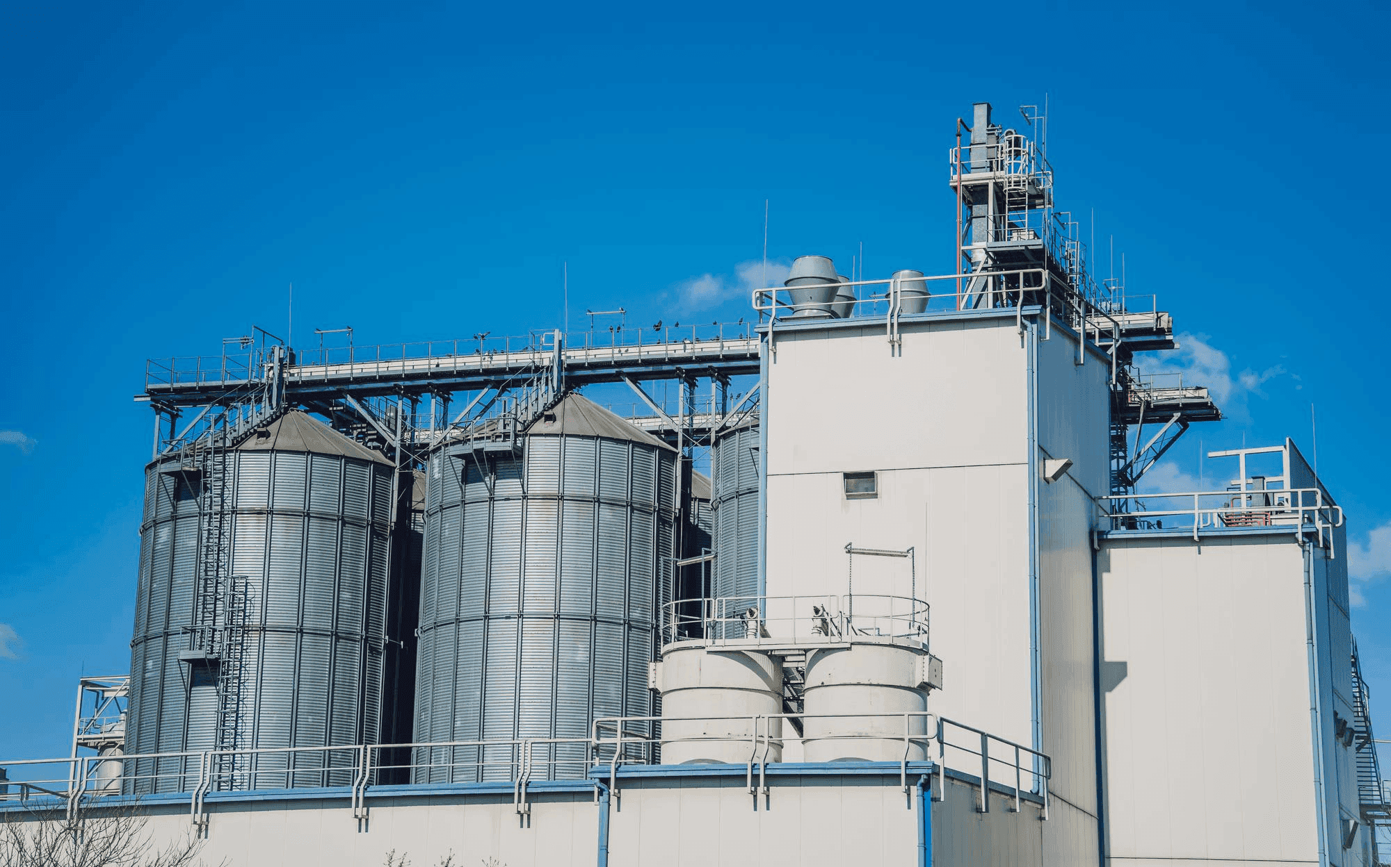 JK Cement plant silos under a blue sky